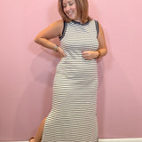 Black and white sleeveless striped midi dress worn by a woman against a pink wall
