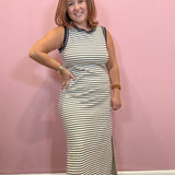 Black and white sleeveless striped midi dress worn by a woman against a pink wall