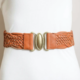 A tan leather belt with braided detailing and a gold-toned oval buckle, shown worn on a white dress form.